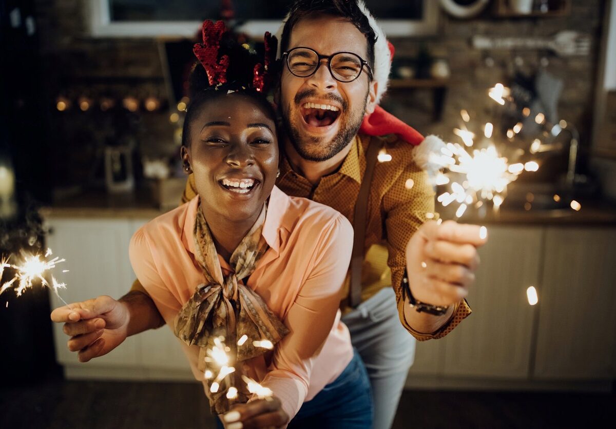 An enthusiastic couple poses with sparklers to celebrate the new year.