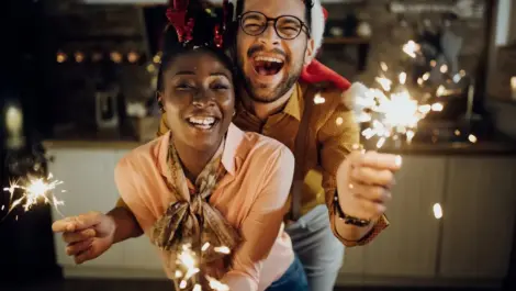 An enthusiastic couple poses with sparklers to celebrate the new year.