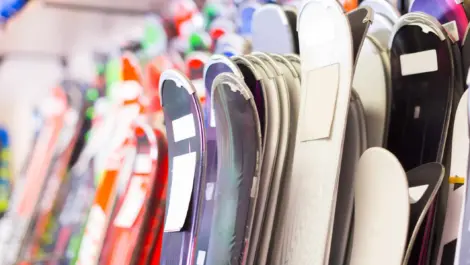 A large selection of skis arranged vertically on racks.