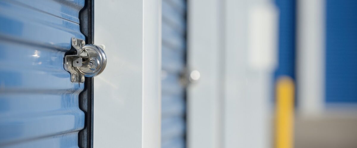 A secure lock on a blue self storage unit door at a storage facility.