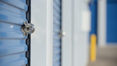 A secure lock on a blue self storage unit door at a storage facility.