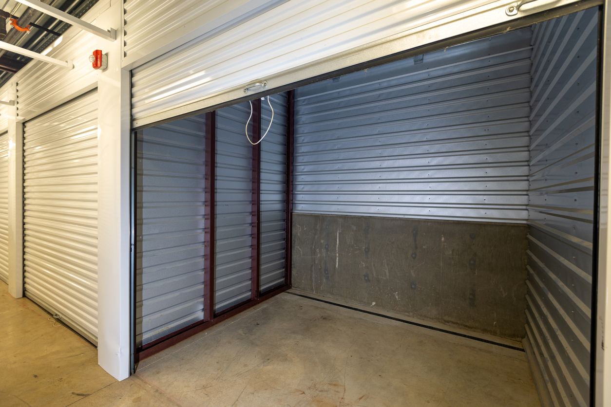 An empty storage unit with its door rolled up.