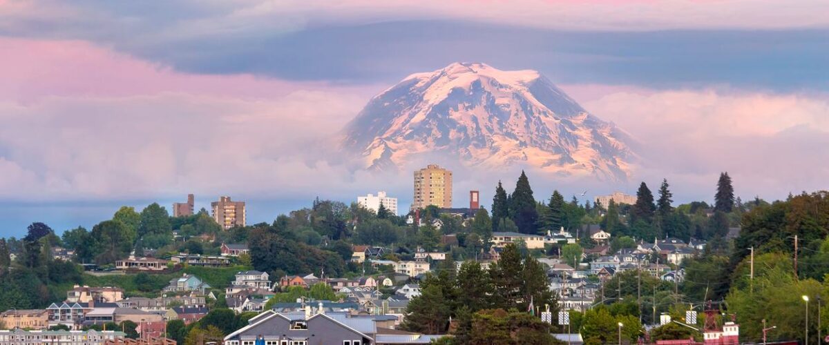 Tacoma, WA, waterfront with neighborhood homes and docks, and Mount Rainier towering above the city skyline.